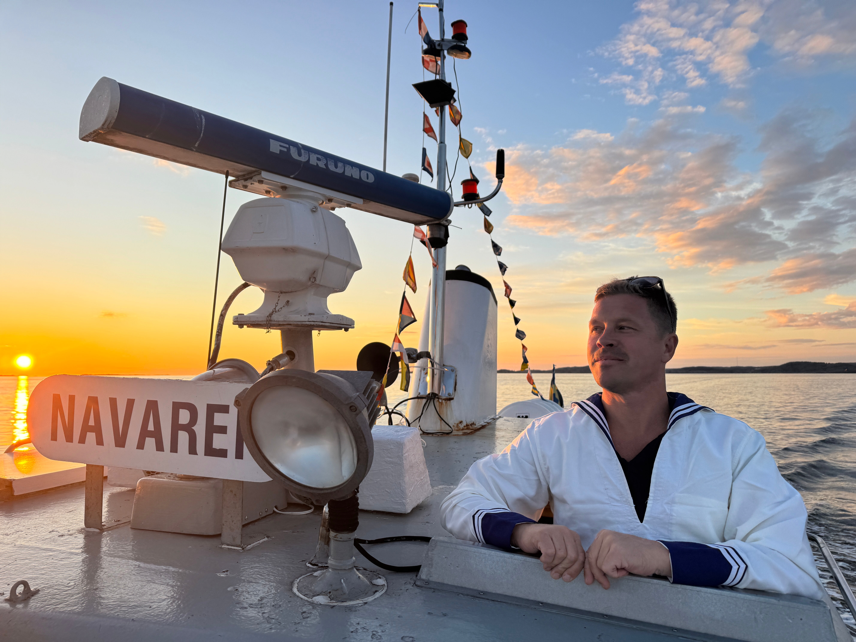 M/S Navaren i solnedgång med svensk flagga